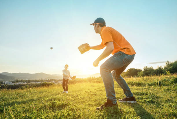 istock Father and son playing in baseball. Playful Man teaching Boy baseballs exercise outdoors in sunny day at public park. Family sports weekend. Father's day. 1247783202