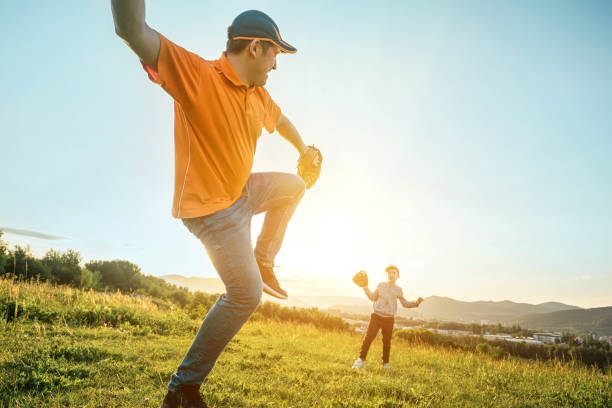 istock Father and son playing in baseball. Playful Man teaching Boy baseballs exercise outdoors in sunny day at public park. Family sports weekend. Father's day. 1247783214