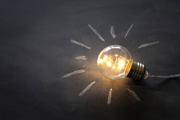 istock Education concept image. Creative idea and innovation. Light bulb as metaphor over blackboard 1247783412