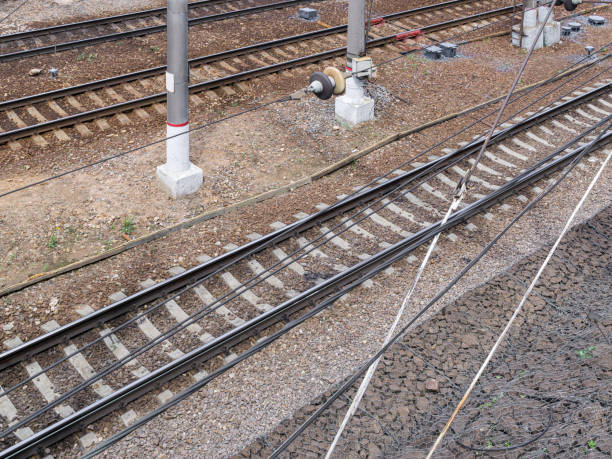 Rails on ballast bed Railroad tracks are on railway embankment of rubble. View from above through power line wires railroad track concrete railway sleeper thoroughfare stock pictures, royalty-free photos & images