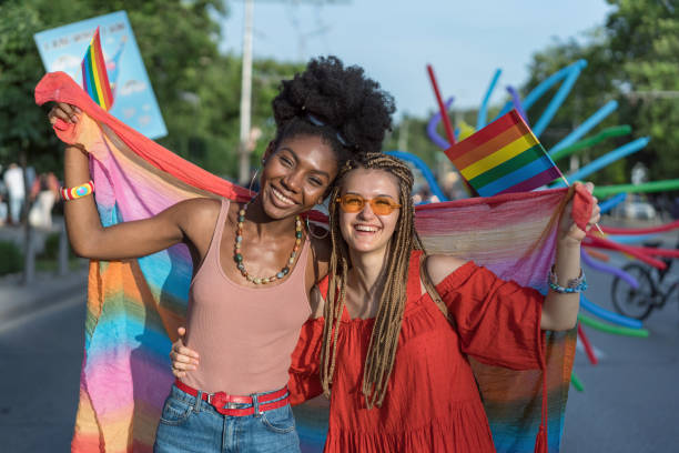 istock Cheerful female couple walking with the pride parade 1247798831