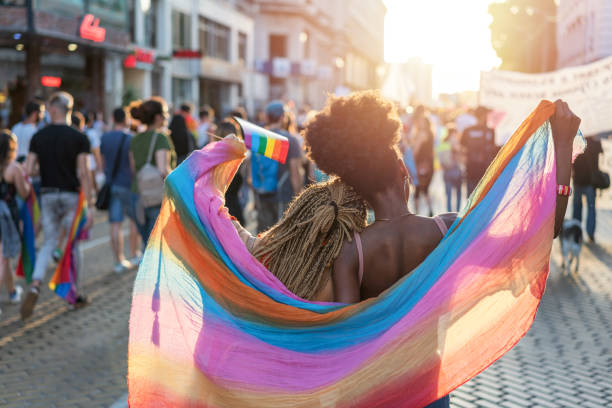 istock Female couple walking with the pride parade 1247798836