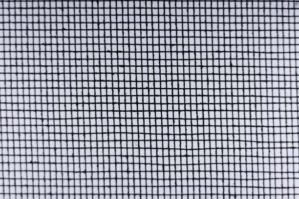 istock Blurred Abstract Minimal style black and whith rays of sunlight cast shadows on the wire mesh steel metal 1247800105