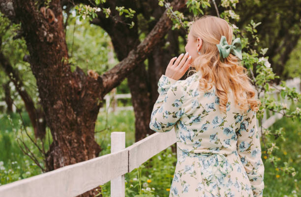 jeune belle fille blonde avec l’arc dans les cheveux posant sur le jardin vert d’été - beautiful hippie blond hair hair care photos et images de collection