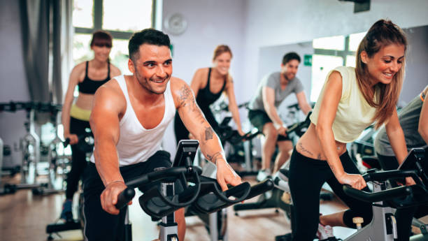 classe di formazione di esercizio - spinning instructor exercising gym foto e immagini stock