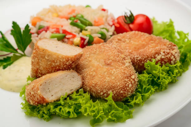 istock Chicken cutlets in batter with risotto and vegetables 1247815384
