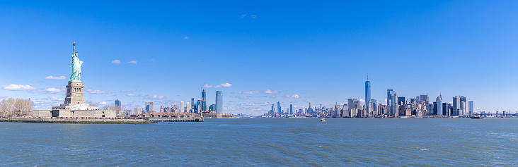 Panoramic landscape of Statue of Liberty with Manhattan downtown Skylines skyscraper building in background, NYC, New York State USA. New York Landmark Travel Destination and cityscape concept.