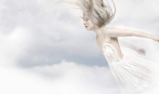 Young and wonderful blonde girl in the image of an angel with white wings.