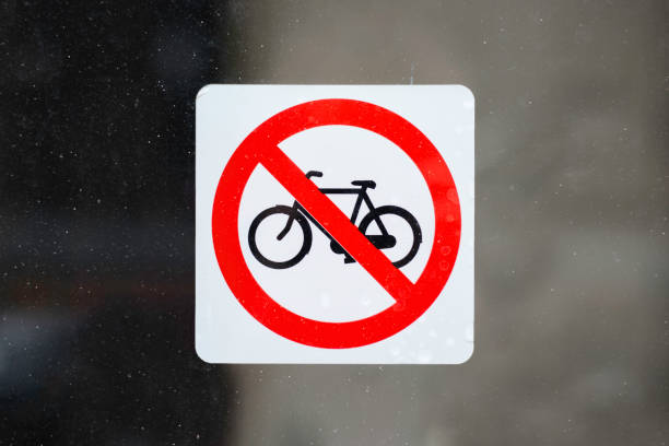 Red with white no bike parking sign, on a dirty window. Bicycles are not allowed Red with white no bike parking sign, on a dirty window. Bicycles are not allowed no parking sign photos stock pictures, royalty-free photos & images