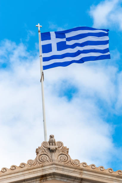 National flag of Greece on the roof of a historic building in Athens.