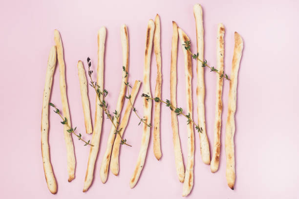istock Homemade Cheese or Bread Sticks with Herds Crispy Bread Sticks with Thyme and Rosemary on Pink Background Top View Horizontal 1247828148
