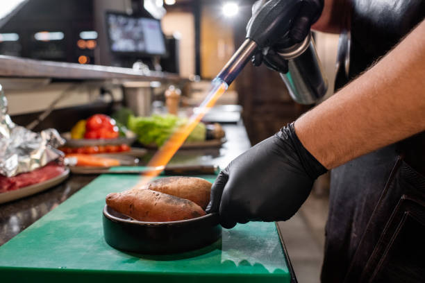 istock Using gas torch for cooking sweet potato 1247829156