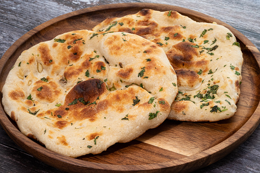 Traditional pita bread on a rustic wood plate
