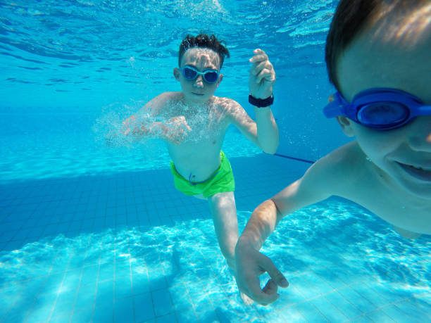 istock Child boy swimming pool water playing summer vacation fun 1247864043
