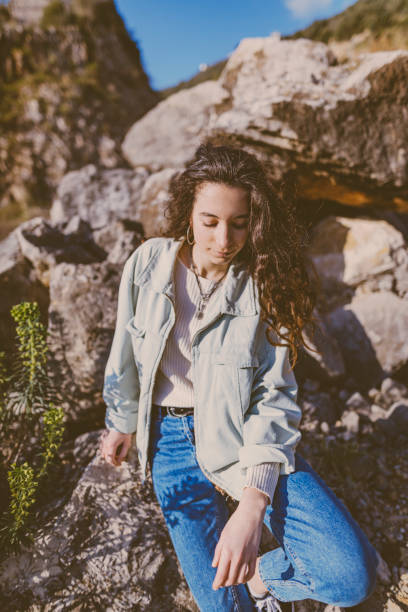 istock hipster girl sitting on the stone 1247864044