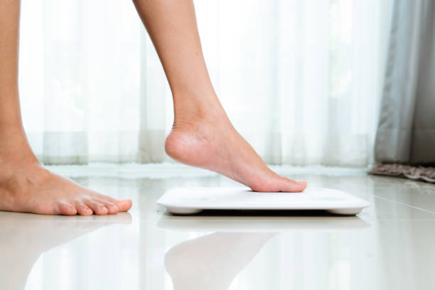 gamba femminile calpesta squame bianche a casa - weight scale dieting weight loss foto e immagini stock
