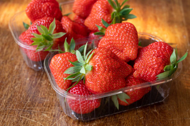 istock Fresh ripe sweet pink lambada strawberry in plastic boxes ready to eat 1247866869