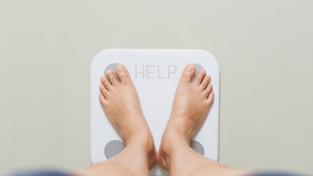 과체중 여성은 help 단어와 함께 집에서 흰색 비늘에 서있다 - dieting overweight weight scale help 뉴스 사진 이미지