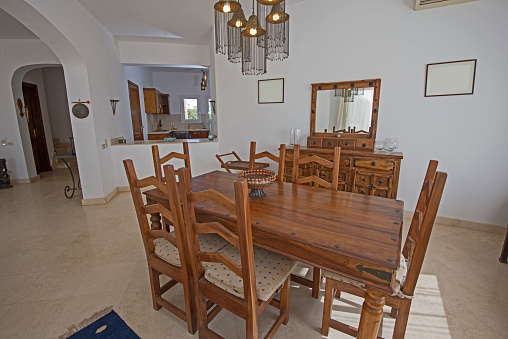 Dining area in luxury villa show home showing interior design decor furnishing with wooden dining table