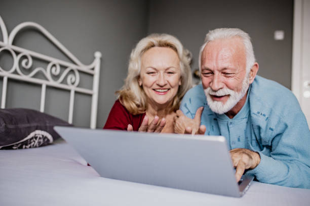 istock Senior couple in bed using laptop 1247875302