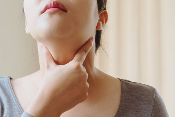 women with thyroid gland test . endocrinology, hormones and treatment. inflammation of the sore throat - touching neck imagens e fotografias de stock