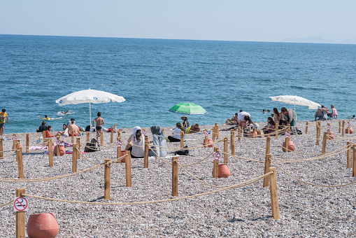 Antalya,Turkey -5 June 2020 : Antalya Konyaalti Beach with people. Due to coronavirus pandemic restrictions by the government, beaches has been completely with Social Distance