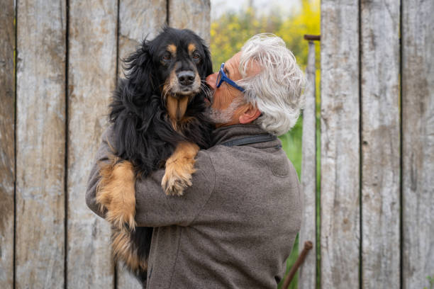 istock Man in his 60s cuddling his dog 1247884269