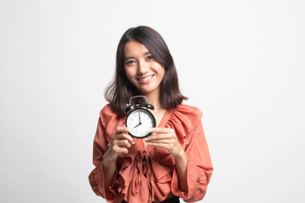 istock Young Asian woman smile with a clock . 1247892227