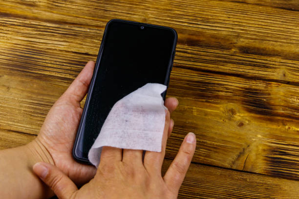 istock Woman hand cleaning smartphone screen with a wet wipe 1247898310