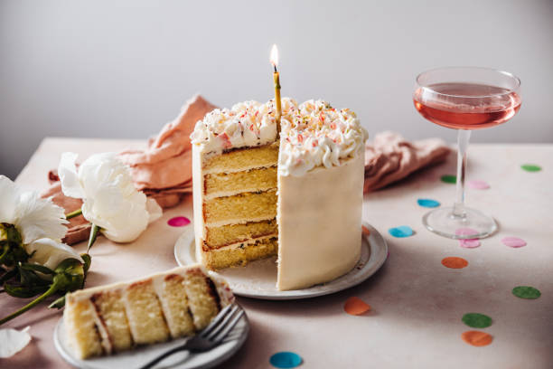 Passion fruit birthday cake Homemade layered cake decorated with cheese cream icing and multi colored sugar sprinkles. Beautiful birthday cake with candle on a table. cake stock pictures, royalty-free photos & images