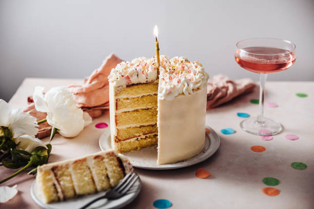 Passion fruit birthday cake Homemade layered cake decorated with cheese cream icing and multi colored sugar sprinkles. Beautiful birthday cake with candle on a table. gateau stock pictures, royalty-free photos & images