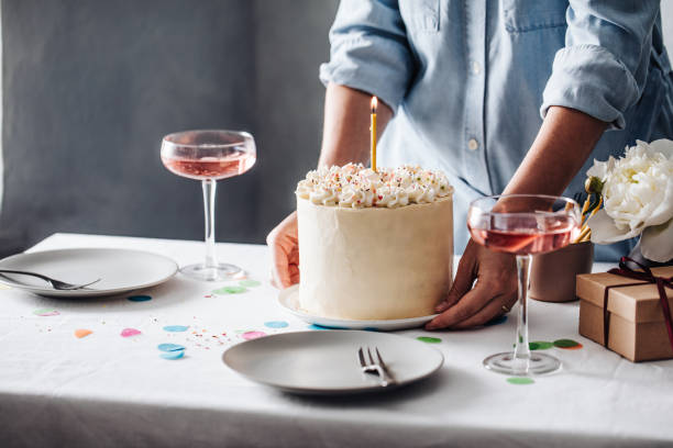 Woman setting up table for birthday celebration Hands of a woman placing birthday cake on table with wine glasses on side. Close-up of a female setting up table for birthday celebration. curd cheese photos stock pictures, royalty-free photos & images