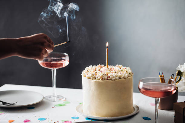 Close-up of a woman igniting birthday candle Close-up of a female hand burning birthday candle with a match stick. Cropped shot of a woman igniting birthday candle over a cake. gateau stock pictures, royalty-free photos & images