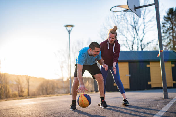 istock Handsome young man trying to score some points during a basketball game against his sister. 1247921586