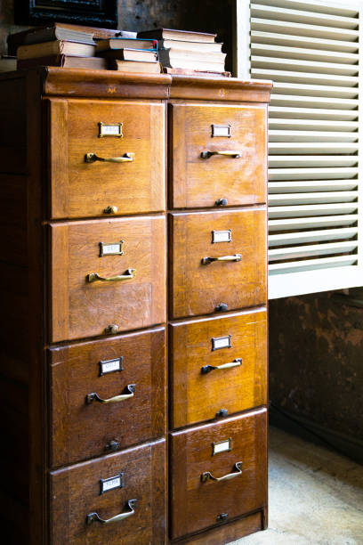 A large balck filing cabinet with five drawers stands next to a two drawer small filing cabinet isolated over 100% white background with cast shadow. Each have a precise clipping path. Canon 5D MarkII DSLR.