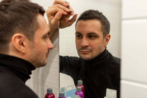 istock reflection of a young guy looking in a mirror. 1247934790