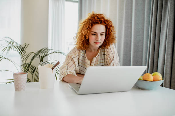 istock Young redhead woman is working from home 1247942433