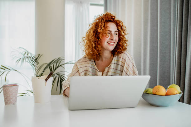 istock Young redhead woman is working from home 1247942434