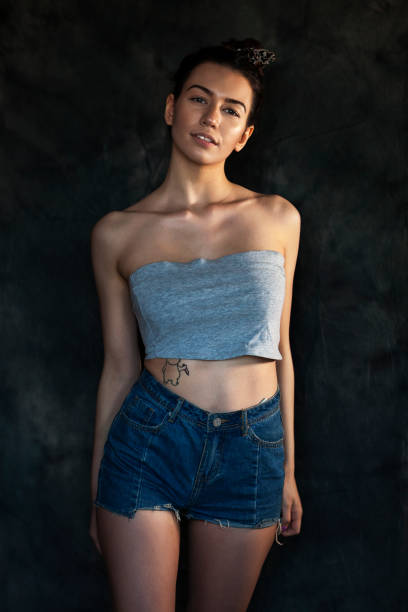 istock Young woman in blue jeans shorts 1247965131