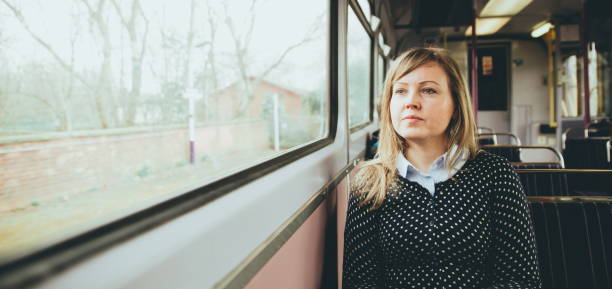 istock Young woman on a train looking out the window while sitting during travel on a train. Enjoying travel on train or tube. Young woman on train sitting and relaxing. railroad transport. planning route of transport. young woman in train. young woman relaxing 1247965546
