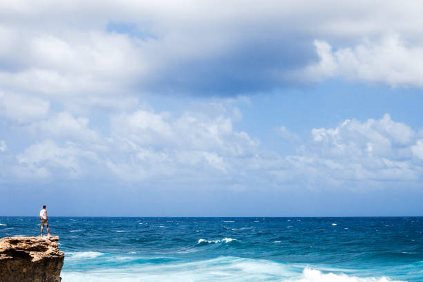 Man standing on the rocky coast. Pie Corner, Barbados