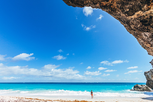 Man standing at sandy beach. Bottom Bay, Barbados