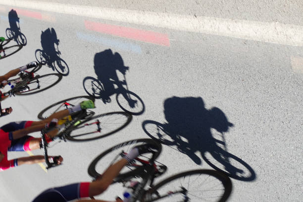 radfahrer mit schatten, radrennen - bahnradsport stock-fotos und bilder