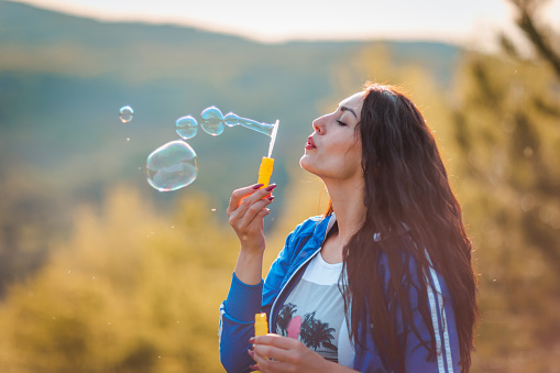 Woman blowing bubbles.