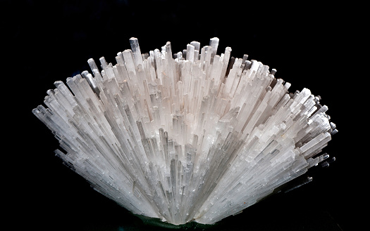 Scolecite crystals of the zeolite group. Geology; Mineral; Scolecite; Silicate class; acicular needle like formation; color image; crystal form; horizontal; hydrated calcium silicate; luster; mineralogy; photograph; photography; pseudotetragonal crystal; spray of thin prismatic needles; tectosilicate mineral; vitreous luster; white; zeolite group