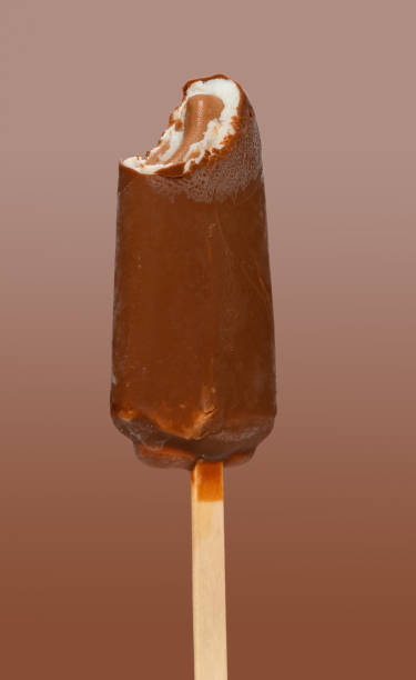 istock fresh chocolate outer popsicle with blueberry sauce inside with a bite on brown background 1247996695