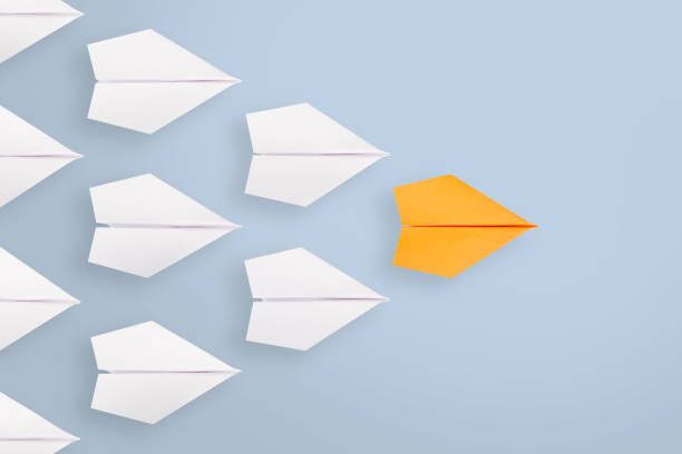 istock Leadership concepts with orange paper airplane leading among white 1248012538