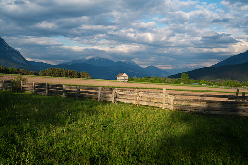 Sunset on the alpine countryside in summer with fence and barn, and dramatic cloudscape Mieminger Plateau, Tyrol, Austria