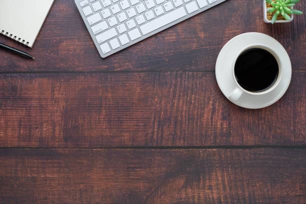 istock Workspace in office with wood table. Top view from above of keyboard with notebook and coffee. Desk for modern creative work of designer. Flat lay with blank copy space. Business and finance concept. 1248036877