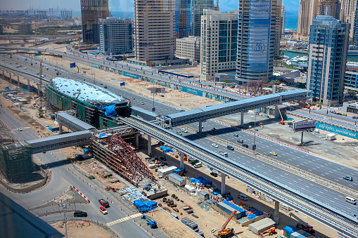 Dubai, United Arab Emirates - April 05, 2009: The Jumeirah Lake Towers Metro station is under construction. The design is modern. This is one of the elevated stations on Sheikh Zayed Road. In the background are some towers of the Dubai Marina area. Horizontal format..